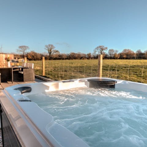 Immerse yourself in the warmth of the hot tub as the sun sets
