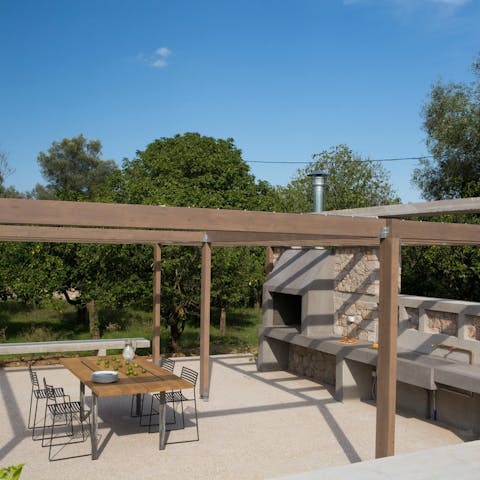 Dine outdoors thanks to the summer kitchen surrounded by olive trees