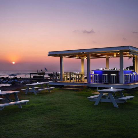 Watch the sunset with a cocktail at the beach bar