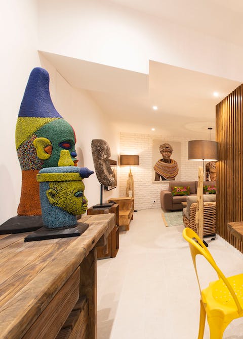Admire the vibrant ethnic artwork and sculptures across the apartment