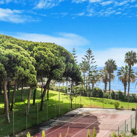 Play a game on the tree-shaded tennis court