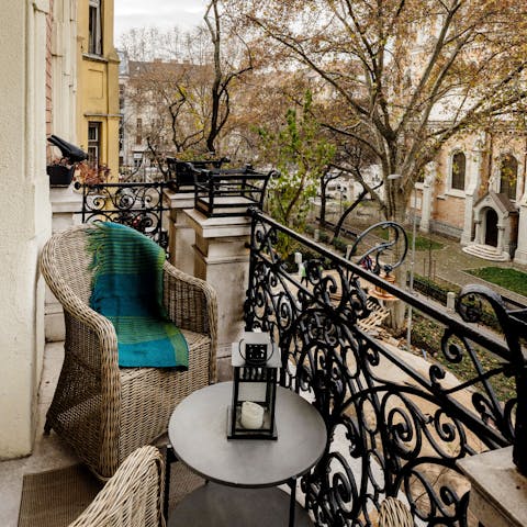 Unwind after a busy afternoon on the balcony, overlooking plane trees in the square