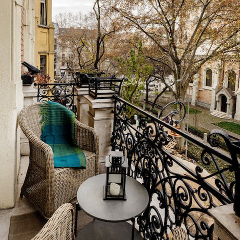 Unwind after a busy afternoon on the balcony, overlooking plane trees in the square