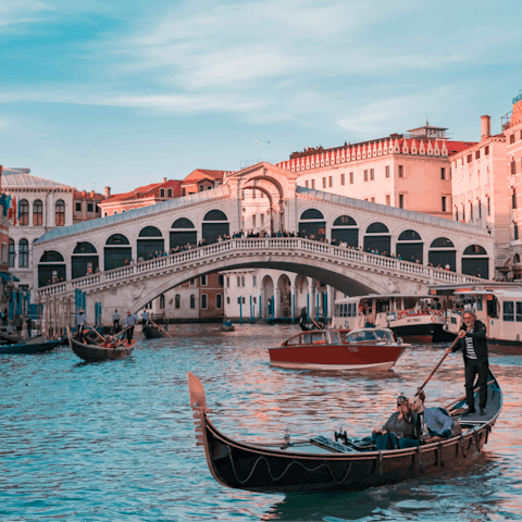 Traverse the Grand Canal in a gondola and visit the famous Rialto Bridge