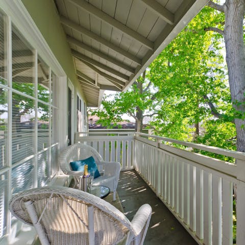 Read a book on the balcony, surrounded by leafy trees