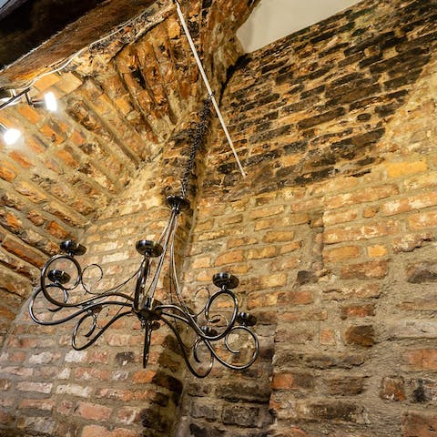 Admire striking original brickwork, illuminated by the chandelier