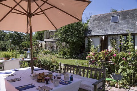 Dine outside in the back garden in among mature rose bushes