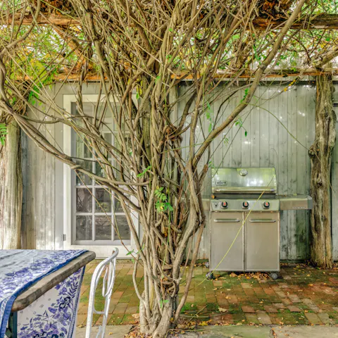 Cook up a feast on the gas barbecue and dine under the wisteria