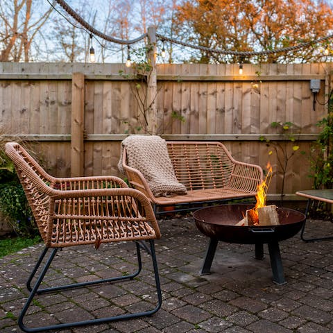 Light up the fire pit once the sun's gone down and watch the crackling flames