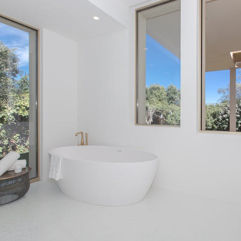 Sink back into soothingly warm water in the elegant freestanding bathtub