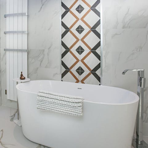 Relax and unwind with a luxurious bath in the sleek bathroom 