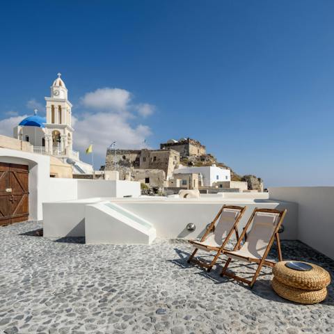 Watch the sun set over Akrotiri with a glass of wine in hand