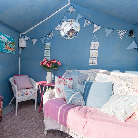 Relax on the pastel furnishings in the cosy summerhouse