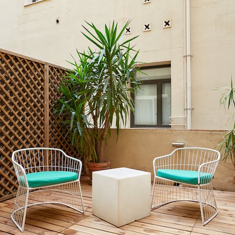 Get some fresh air on your private terrace, complete with leafy trees and seating