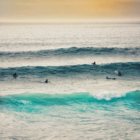 Take off on perfect peeling waves at Fistral Beach, a thirty-minute drive away