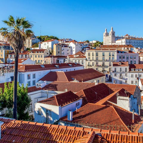 Watch the sunset from the Miradouro de Santa Luzia with a glass of green wine in hand