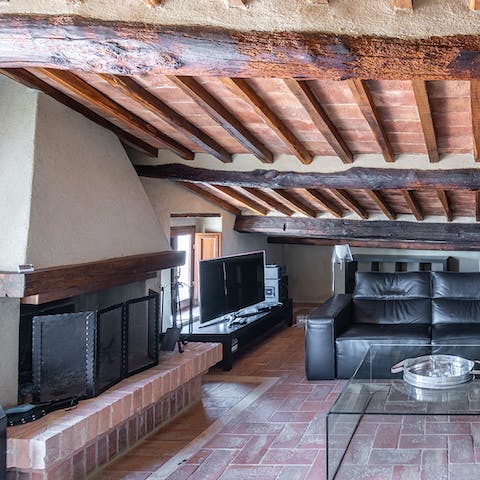 Snuggle up next to the traditional fireplace under the ceiling beams in the living room