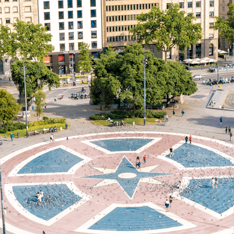 Wander about Plaça de Catalunya's fountains and statues, only two minutes' walk from your front door