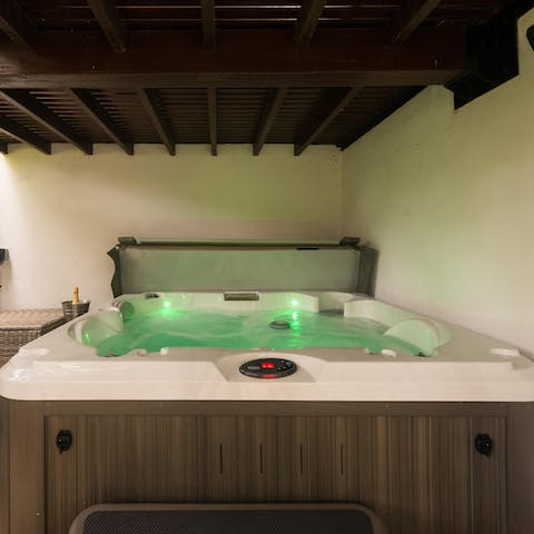 Relax and unwind in the hot tub, a glass of bubbly in hand