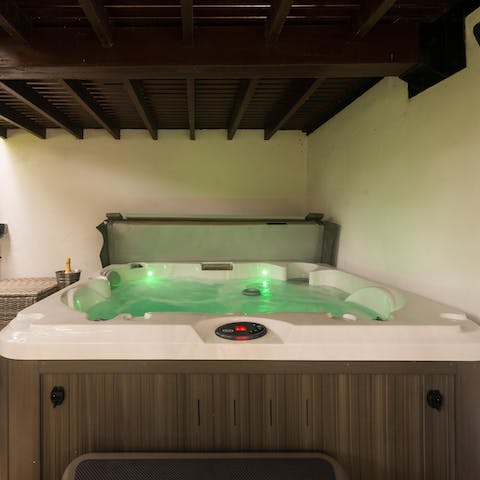 Relax and unwind in the hot tub, a glass of bubbly in hand