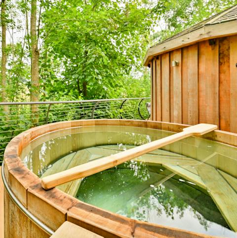 Unwind in the tree-top, wood-fired hot tub with a glass of crisp white wine