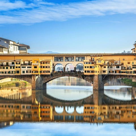 Admire the iconic Ponte Vecchio from the river's edge