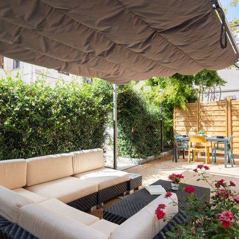 Sink into the comfortable outdoor seating, beneath the retractable shade