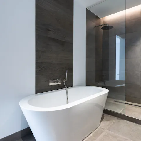 Unwind in the contemporary bathroom with a raw aesthetic at the end of a tiring day 