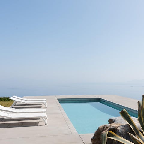 Look out at the hazy Aegean sea from your private pool