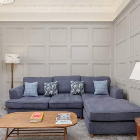 Settle in on the L-shaped sofa in the wood-panelled living room