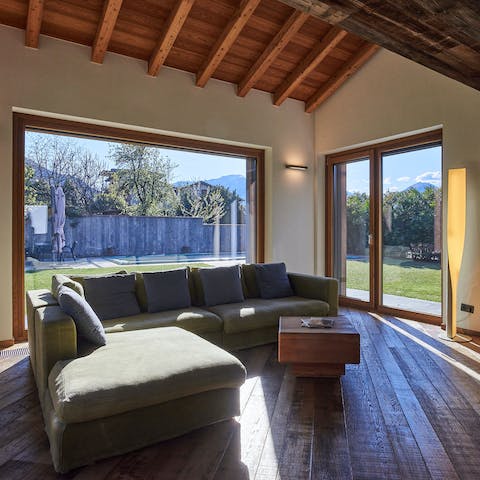 Relax in the sunny living room, courtesy of floor-to-ceiling glass