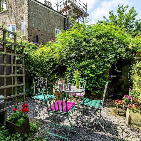 Enjoy evening tipples as the sun sets in the pretty courtyard-style garden