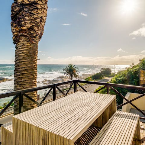 Sit on the wooden table on the balcony with a cup of coffee, feeling the sea breeze greet the skin