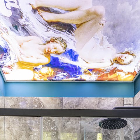 Shower under luminous paintings in the stylish bathroom