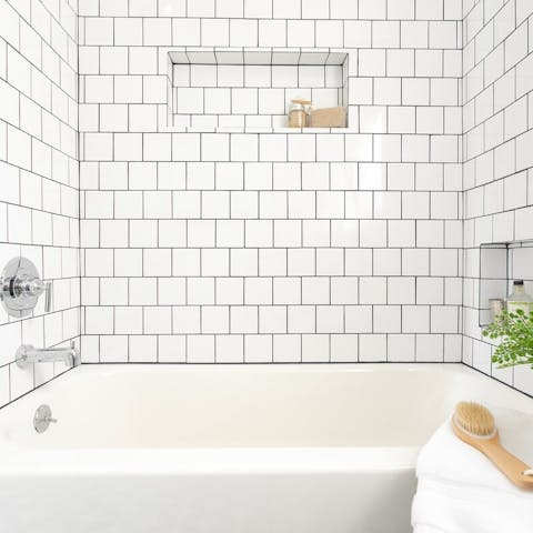 Treat yourself to an indulgent soak in the pristinely tiled bathtub