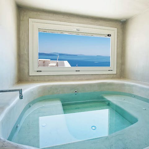 Unwind with a soak in the private hot tub, looking out on the blue sea below