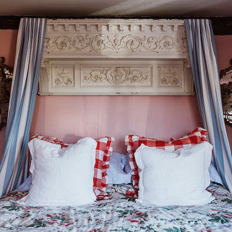 Drift off to dreamland underneath a restored mantlepiece, now used as a headboard