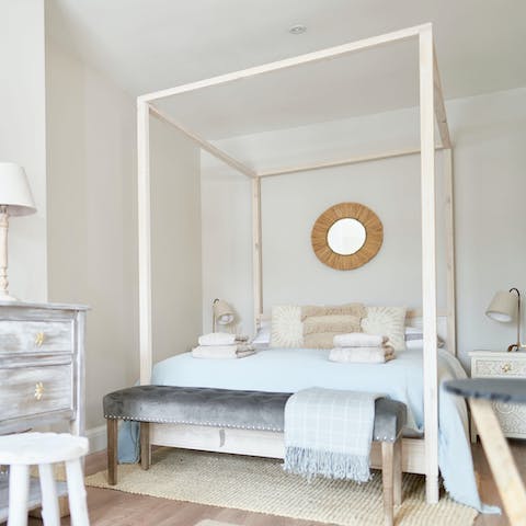 Drift off to sleep in the beachy four-poster bed