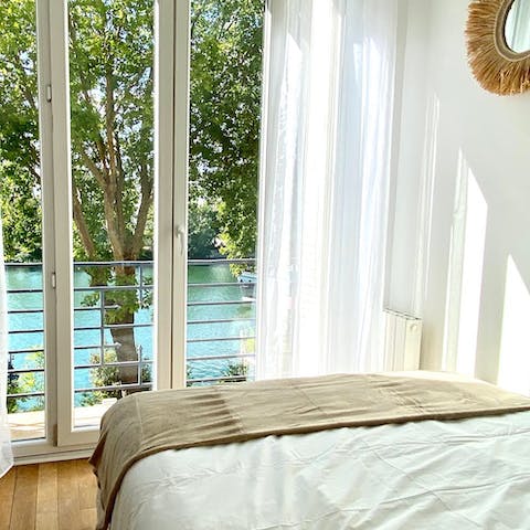 Wake up to a view of the Seine, framed by flickering trees