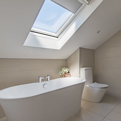 Enjoy a long soak in the freestanding tub as sunlight streams in through the skylight
