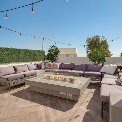 Light the fire pit and enjoy evenings on the roof terrace against a backdrop of city lights