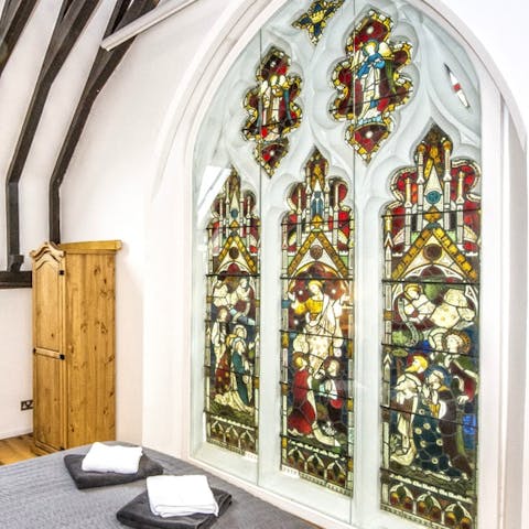 Wake up to spectacular stained glass scenes in the master bedroom