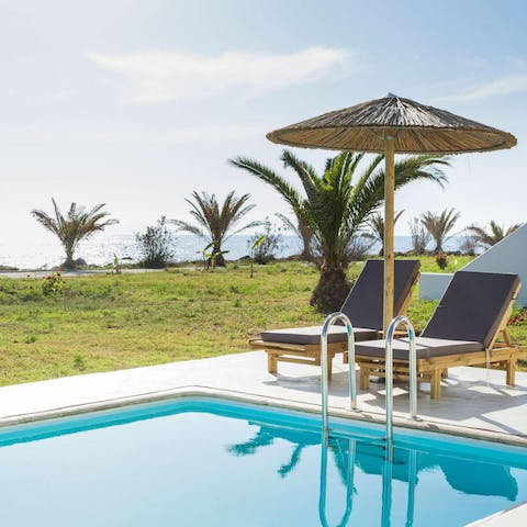 Soak up the sun from the private poolside lounger as the sea provides the backdrop