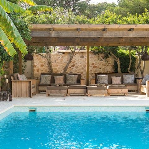 Chill out under the palm-fringed pergola by the poolside