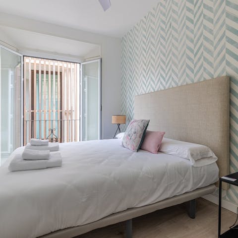 Let the fresh air and sunshine in through the bedroom's balcony's doors