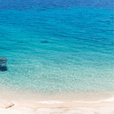 Sink your toes into the white sands of Elia Beach,  just 800m away