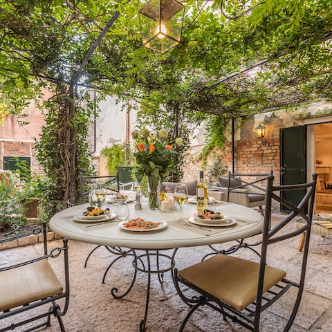 Sit down to a celebratory alfresco meal beneath the vine-covered pergola