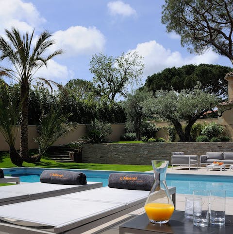 Spend the day lazing by the poolside on loungers between the trees