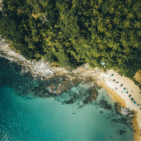 Cool off in the turquoise waters of Surin Beach, a twelve-minute walk from home