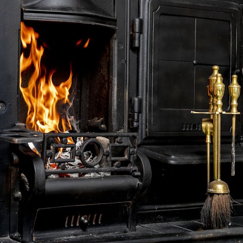 Cosy up by the stunning fireplace, complete with fire tools